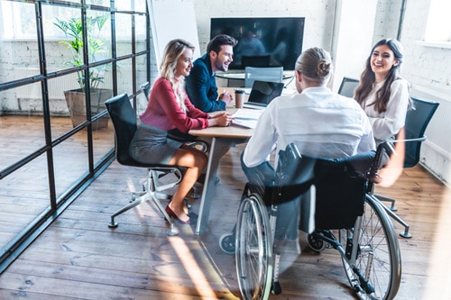 Réunion de travail avec une personne en fauteuil roulant